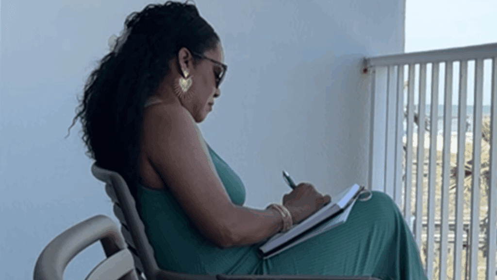 Woman journaling outdoors in natural light, symbolizing balance, confidence, and purpose after 40.