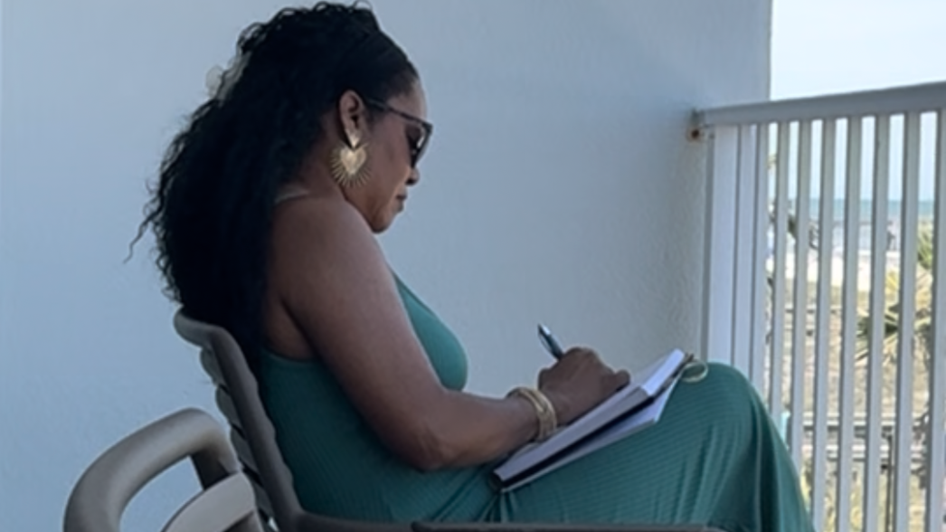 Woman journaling outdoors in natural light, symbolizing balance, confidence, and purpose after 40.