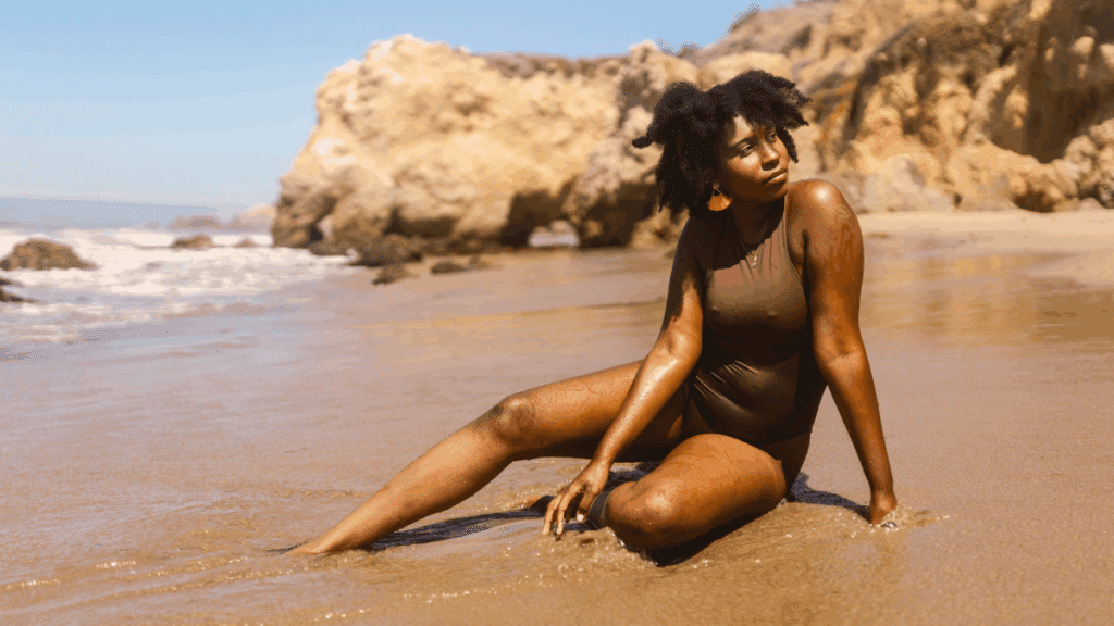 Confident midlife woman sitting on the beach, embracing peace, freedom, and self-assurance.