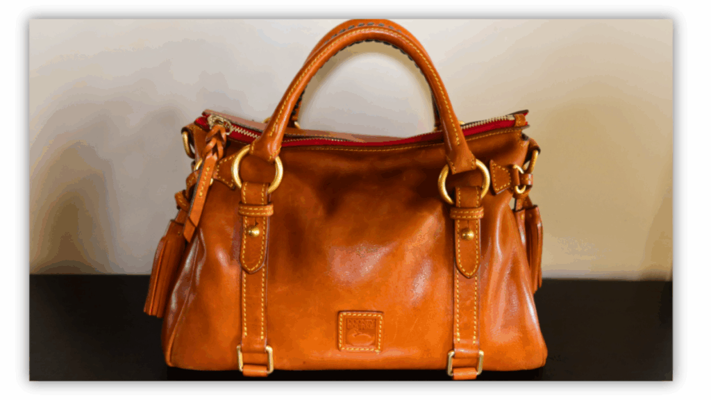 Dooney & Bourke Florentine leather handbag in caramel brown with gold hardware, showcasing timeless craftsmanship and classic style